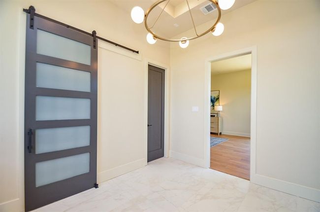 Door to primary closet and water closet. Open door leads to primary bedroom. | Image 18