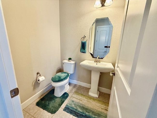 Bathroom featuring toilet, tile patterned floors, a sink, and baseboards | Image 25