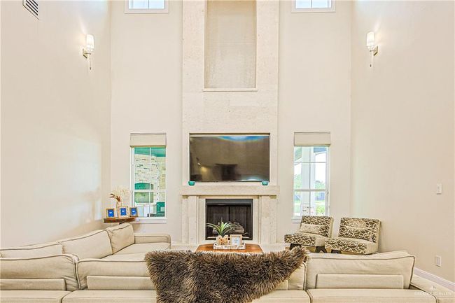 Living room with a high ceiling, a premium fireplace, and healthy amount of natural light | Image 15