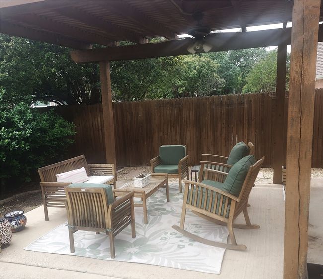 View of pergola covered patio lounge area equipped with a fan. | Image 29