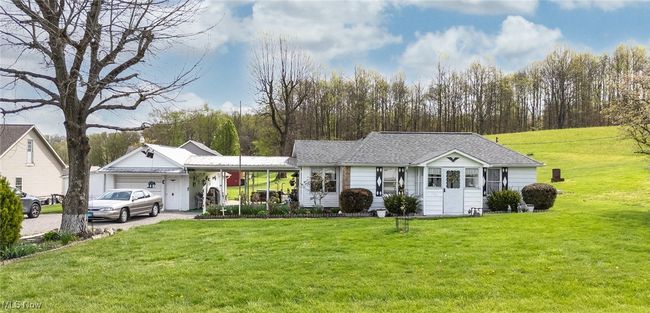 Ranch-style house with driveway, roof with shingles, a front lawn, and a garage | Image 41