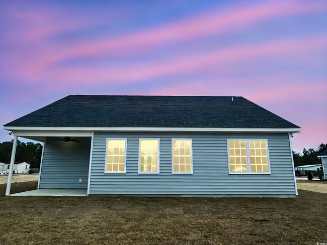 Back house at dusk with a lawn and a patio area | Image 22