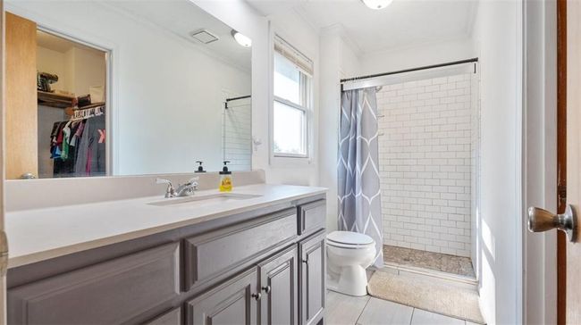 Bathroom with vanity, ornamental molding, a shower stall, and a walk in closet | Image 11
