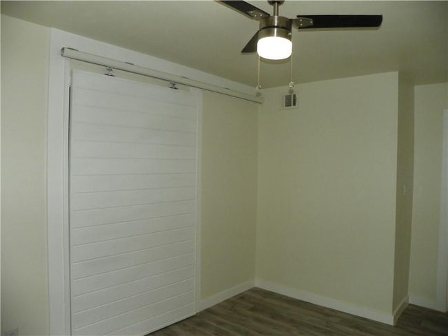 Spare room with dark wood-style flooring and a ceiling fan | Image 11