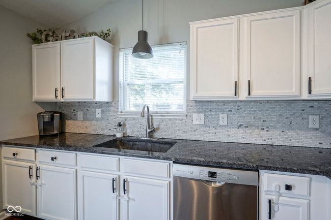 kitchen with a sink, dishwasher, white cabinetry, and tasteful backsplash | Image 16