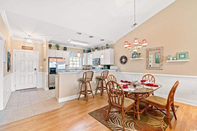 Dining room with a chandelier, a wainscoted wall, light wood finished floors, and ornamental molding | Image 15