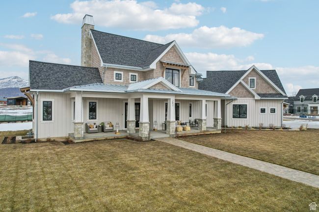 View of front of house with board and batten siding, covered porch, roof with shingles, and a front lawn | Image 57