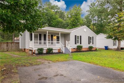 Ranch-style home featuring a porch and a front yard | Image 2