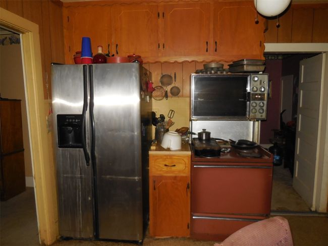 Kitchen with range with electric cooktop, stainless steel refrigerator with ice dispenser, and light countertops | Image 9