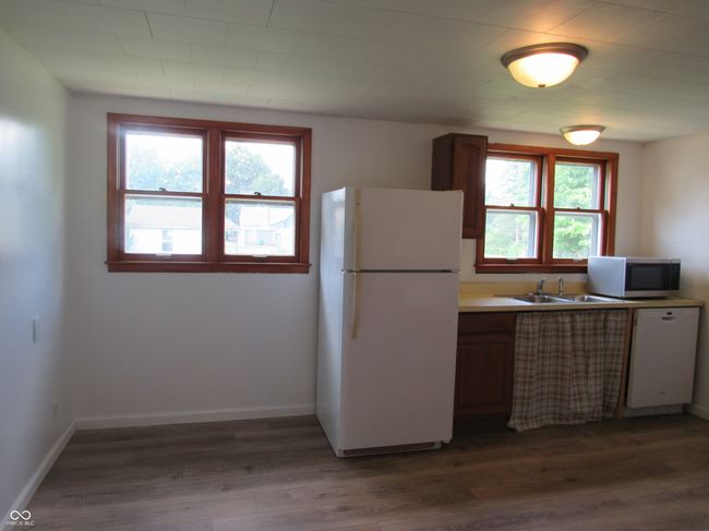 kitchen with white appliances, plenty of natural light, and dark wood finished floors | Image 11