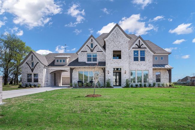 French country inspired facade with a front yard, brick siding, concrete driveway, and a shingled roof | Image 36