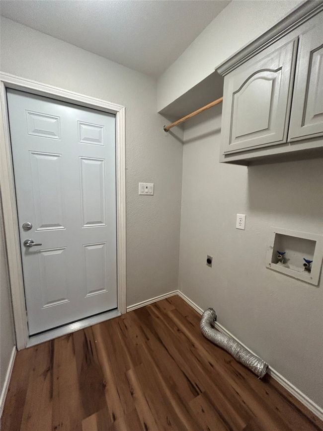 Laundry area with cabinet space, hookup for an electric dryer, dark wood-style floors, and washer hookup | Image 21