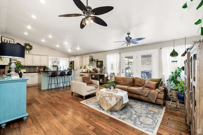 Living room with recessed lighting, vaulted ceiling, a ceiling fan, and hardwood / wood-style flooring | Image 6