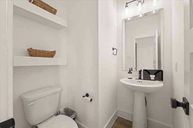 Half bathroom featuring toilet and wood finished floors | Image 11