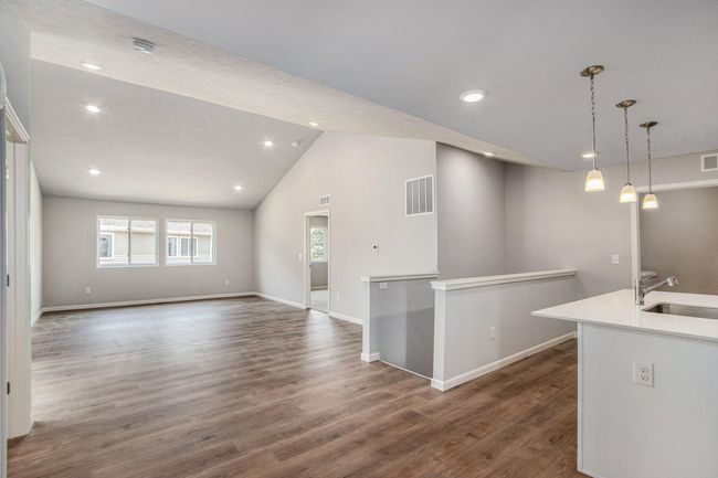 The open concept floorplan has full sight lines into the great room. There is an abundance of natural lighting from windows and is further enhanced by the vaulted ceilings and recessed lighting. | Image 8