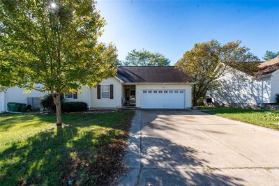 View of front with a front yard and a garage | Image 1