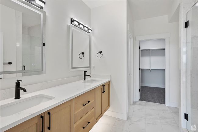 Full bathroom featuring a spacious closet, marble finish floor, baseboards, and a sink | Image 12