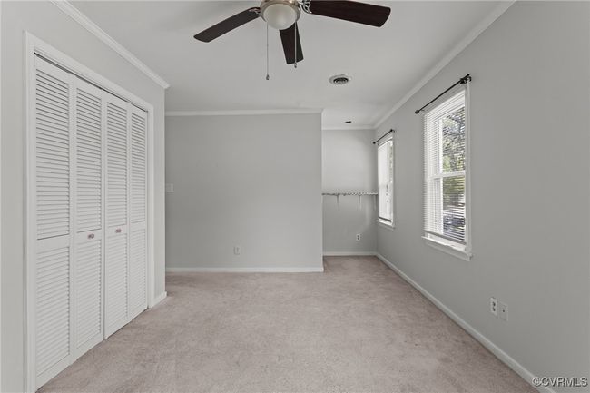 Unfurnished bedroom with visible vents, baseboards, carpet, and ornamental molding | Image 31