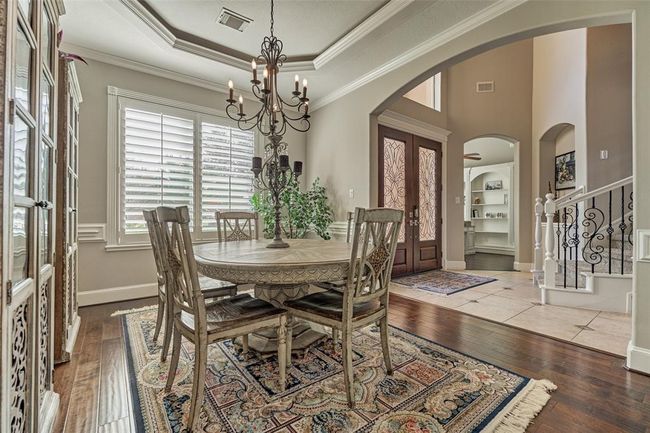 Discover the elegant formal dining room at the front of the home, featuring cove lighting and abundant natural light. | Image 5