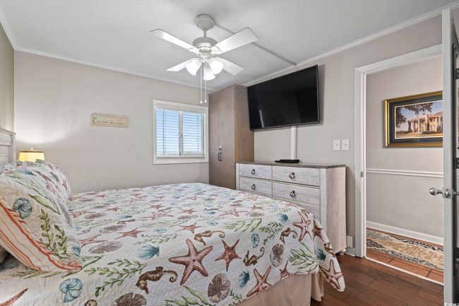 Bedroom featuring a ceiling fan, ornamental molding, and dark wood-style flooring | Image 8