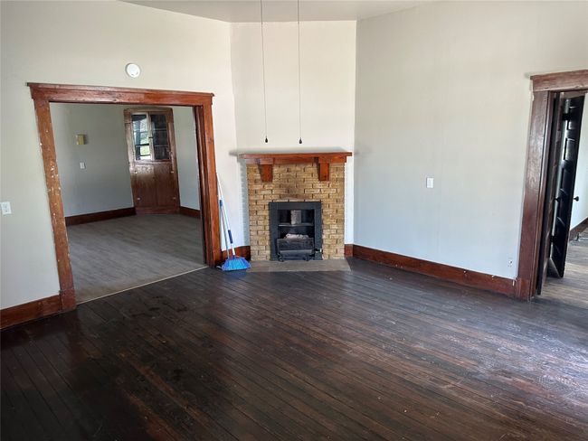 Unfurnished living room featuring baseboards, a fireplace, and hardwood / wood-style flooring | Image 13