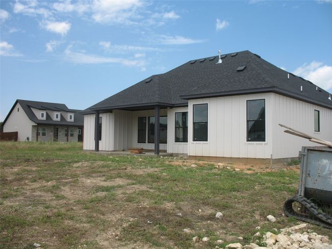 Rear view of house with board and batten siding and roof with shingles | Image 22