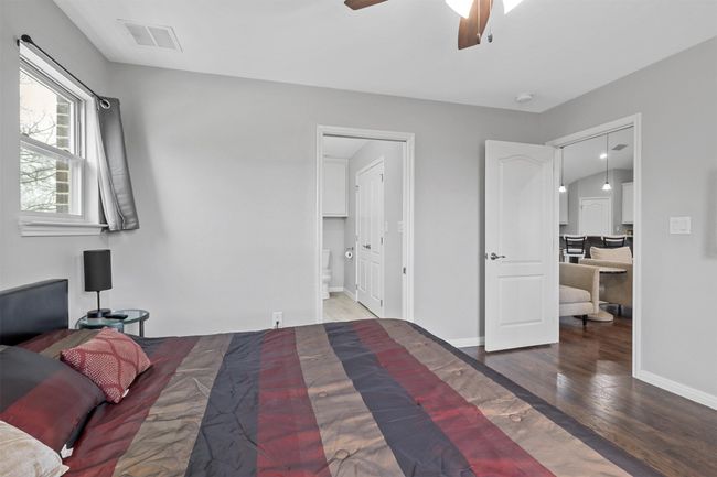 Bedroom with baseboards, visible vents, wood finished floors, and ensuite bath | Image 14