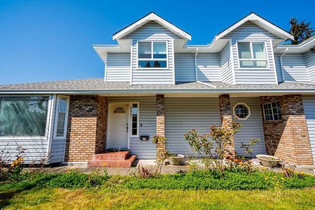 View of front of property featuring covered porch, brick siding, and roof with shingles | Image 31