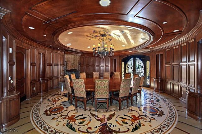 Dining space with inlaid floor details, arched walkways, a raised ceiling, a chandelier, and crown molding | Image 31