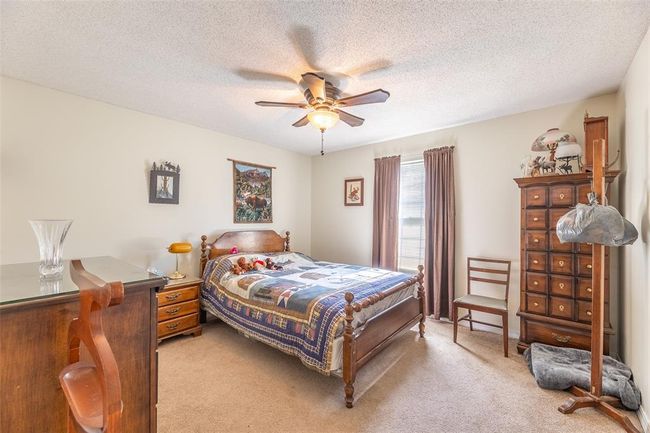 Bedroom with light colored carpet, a textured ceiling, and a ceiling fan | Image 21