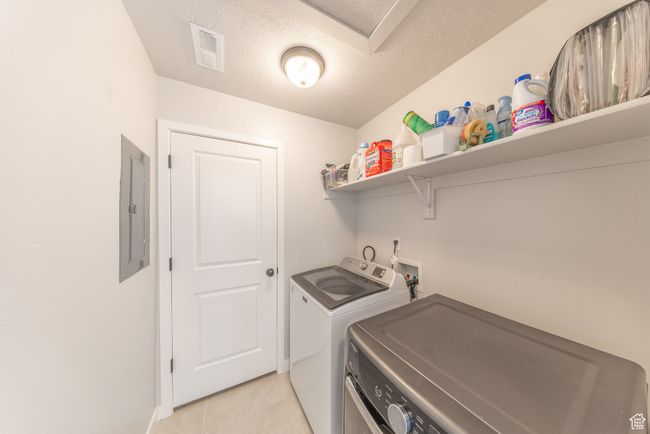 Laundry area with washer and clothes dryer, electric panel. | Image 20