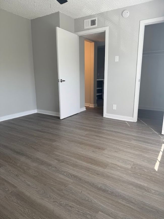 Unfurnished bedroom with dark wood-style floors, baseboards, a closet, and a textured ceiling | Image 17