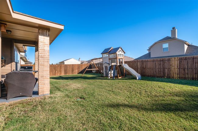 View of yard featuring a playground and a fenced backyard | Image 28