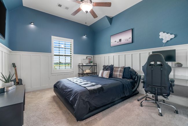 Carpeted bedroom with a wainscoted wall, lofted ceiling, a decorative wall, ceiling fan, and a desk | Image 36