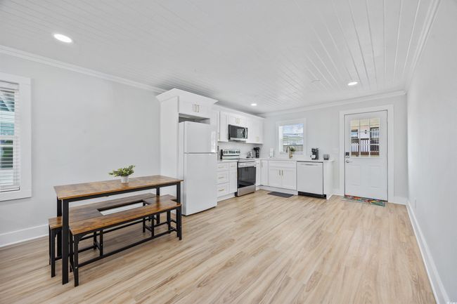 Kitchen featuring stainless steel appliances, crown molding, light wood finished floors, recessed lighting, and light countertops | Image 7