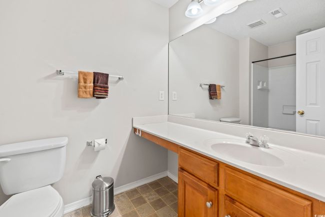 Full bath with toilet, baseboards, vanity, and a shower | Image 16