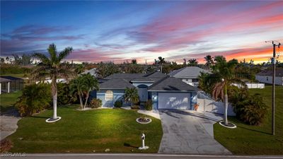 View of front of house with a garage and a lawn | Image 1