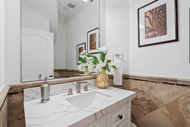 Powder room under the stairs on the main floor, featuring a sleek vanity and modern finishes, offering both style and functionality for guests. | Image 47