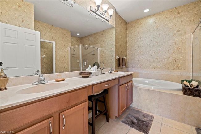 Bathroom featuring a garden tub, double vanity, tile patterned flooring, and a stall shower | Image 20