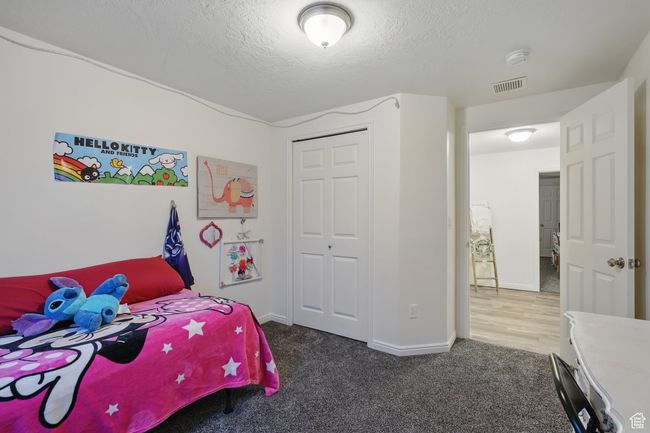 Bedroom featuring baseboards, a closet, carpet flooring, a textured ceiling, and visible vents | Image 40