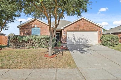 View of front facade with a front lawn and a garage | Image 1