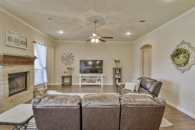 Living room featuring dark wood-type flooring, arched walkways and a stone fireplace | Image 9