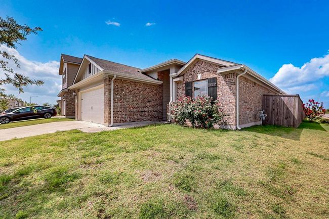 Single story home with brick siding, a garage, and driveway | Image 40