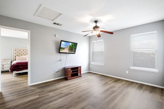 Unfurnished living room featuring wood finished floors, ceiling fan, attic access, and a textured ceiling | Image 10