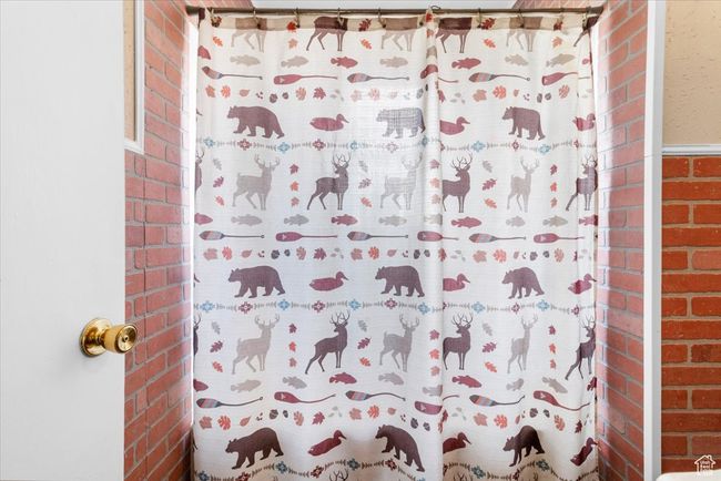 Bathroom with a shower with curtain and brick wall | Image 38