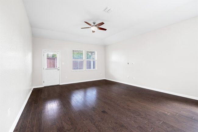 Empty room with ceiling fan and dark wood-type flooring | Image 19