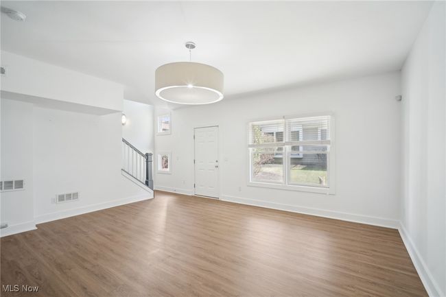 Entrance foyer featuring visible vents, baseboards, wood finished floors, and stairway | Image 27