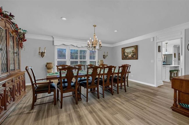 Dining area featuring baseboards, crown molding, a chandelier, wood finished floors, and recessed lighting | Image 20