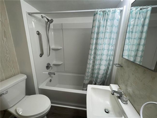 Full bathroom with toilet, sink, and shower / bath combo with shower curtain | Image 13
