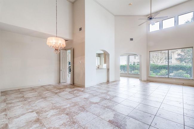 Dining and living space with 18' ceiling gorgeous tile flooring and views of rear yard. | Image 13